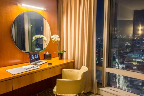 吉隆坡吉隆坡普乐米拉酒店的酒店客房设有书桌和窗户。