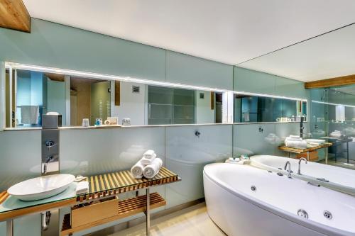 霍巴特亨利琼斯艺术酒店的带浴缸、水槽和镜子的浴室