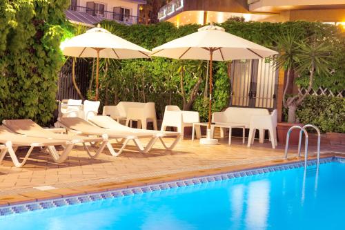 罗列特海岸夏恩公园酒店的游泳池旁的游泳池配有椅子和遮阳伞