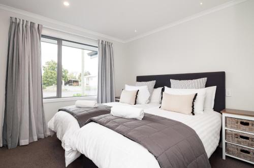 特威泽尔Luxury Rata Apartment - B的一间卧室设有一张大床和一个窗户。