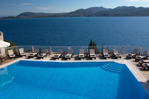 尼基亚娜亚德里亚缇卡酒店的一个带椅子的游泳池,享有水景