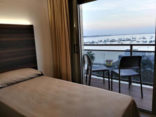 圣地亚哥德拉里贝拉Hotel Ribera的一间卧室设有一张床和一个美景阳台