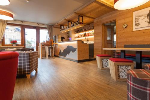 库马约尔Hotel Vallée Blanche Courmayeur的餐厅铺有木地板,配有红色椅子