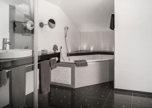 萨尔嫩梅茨根酒店的带浴缸和盥洗盆的浴室