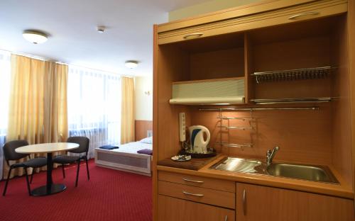 华沙多布勒密斯瑞可了西尼旅馆的一个带水槽的厨房和一张位于客房内的床