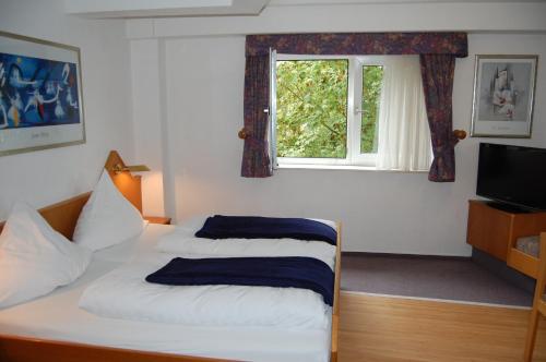 亨内夫约奈尔酒店的一间卧室设有两张床和窗户。
