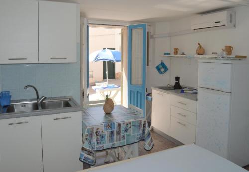 莱乌卡Dimora del Marinaio的厨房配有白色橱柜、水槽和窗户。