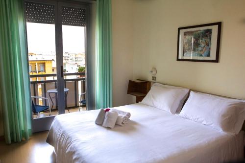 里米尼米拉马雷市酒店的酒店客房,配有带毛巾的床