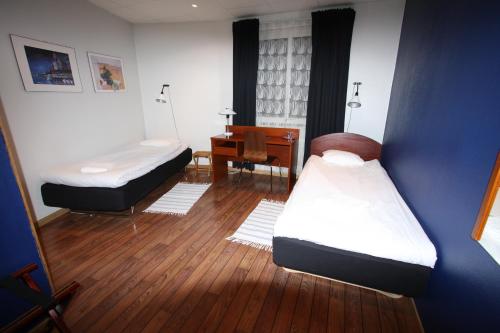 永比林尼亚酒店的客房设有两张床、一张桌子和一张桌子。