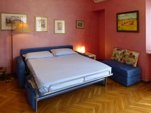 都灵Casa Clemente in Cit Turin的一间卧室配有一张床和一张蓝色的沙发