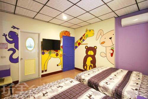 绿岛绿岛禾风旅栈的卧室配有两张床,墙上绘有动物。