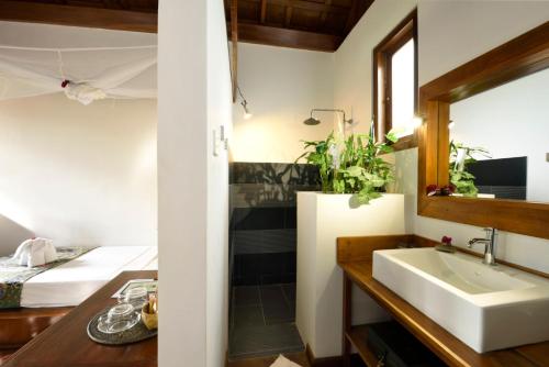 娘瑞拉梅森博马恩精品酒店的一间带水槽的浴室和一张位于客房内的床