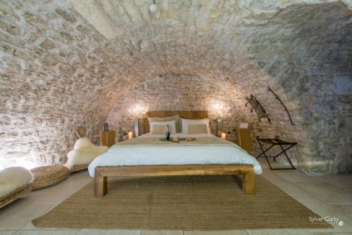 拉罗谢尔Entre Hotes的卧室配有一张石墙床