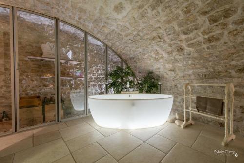 拉罗谢尔Entre Hotes的带浴缸的浴室和石墙