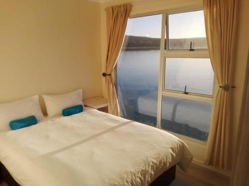 兰格班Kraalbaai Lifestyle House Boats的一间卧室设有一张床和一个大窗户