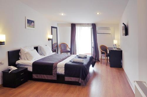 第比利斯科尔诺酒店的酒店客房带一张床、一张桌子和椅子