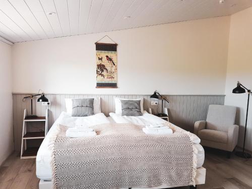 ÞórshöfnGrásteinn Guesthouse的一间卧室配有一张大床和一把椅子