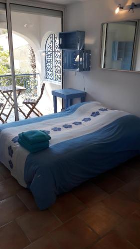 耶尔villa le grilladou的一张床上,床上有蓝色的毯子
