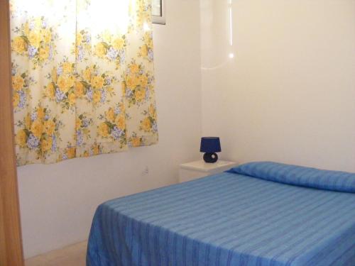 米内尔维诺迪莱切Appartamento Mare e Sole的卧室配有一张床,墙上挂有绘画作品