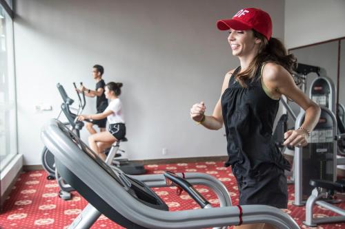 金瓯金瓯省孟清豪华酒店的一名在健身房跑步机上跑步的女人