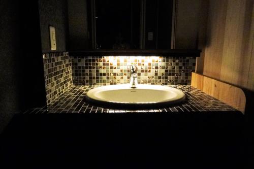京都京町家易碧苏旅馆的黑暗的客房内设有带水槽的浴室