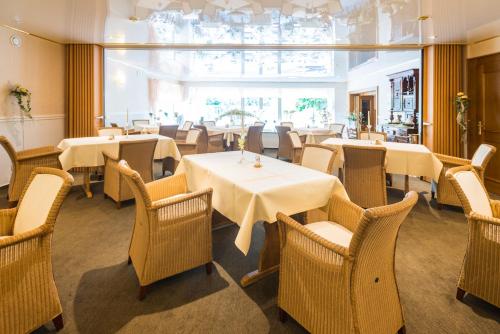 埃迪格尔-埃莱尔苏木鲁文默赛罗曼蒂克酒店的餐厅设有桌椅和大窗户。