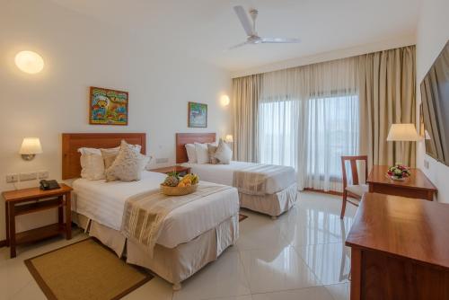 达累斯萨拉姆海崖阁酒店及豪华公寓 的酒店客房设有两张床和一张桌子。