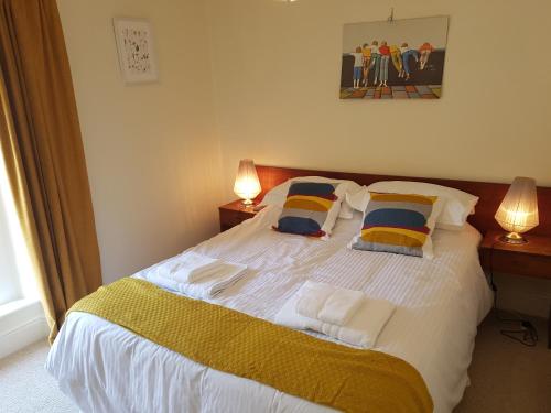 香农河畔卡里克Bridge House的一间卧室配有一张带两盏灯的大型白色床。