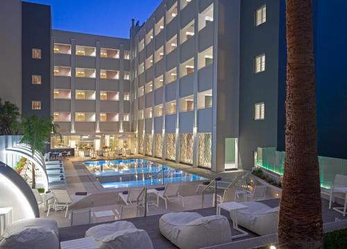 罗希姆诺Melrose Rethymno by Mage Hotels的大楼前设有游泳池的酒店
