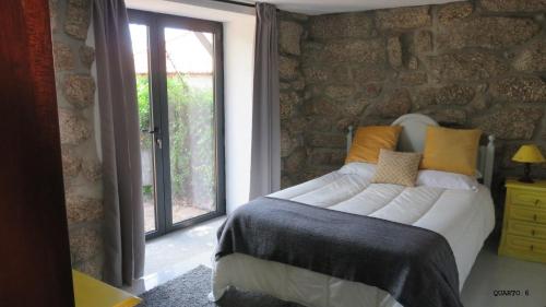 维埃拉·多米尼奥Casa do Contador T3 / T6的一间卧室设有一张大床和一个窗户。