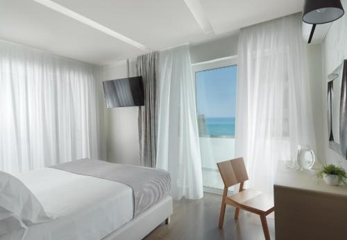 罗希姆诺Melrose Rethymno by Mage Hotels的一间卧室配有一张床,享有海景