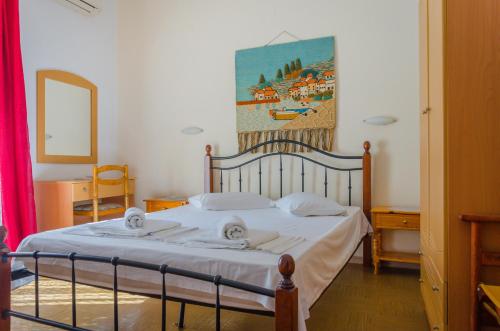 帕纳基雅Hotel Theo的卧室配有一张床,墙上挂有绘画作品