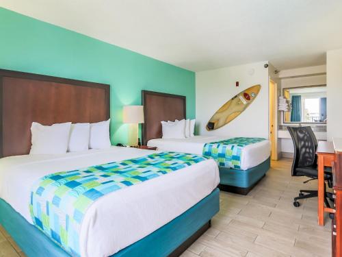 彭萨科拉海滩冲浪和沙滩酒店的酒店客房配有两张床和一张书桌
