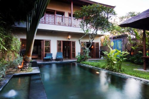 沙努尔阿旃陀别墅酒店的一座房子后院的游泳池