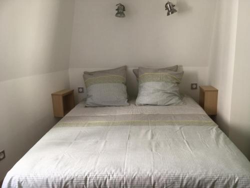 阿布维尔Duplex Little Cottage的一间卧室配有带2个枕头的床