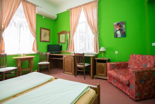 布尔加斯Art Studios Elsor的绿色卧室配有床、书桌和椅子