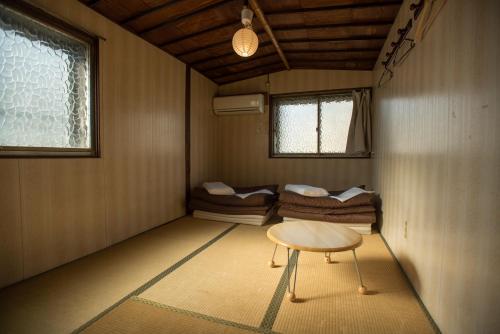 大阪大阪空气旅舍的一间设有一张桌子和一组床铺的房间