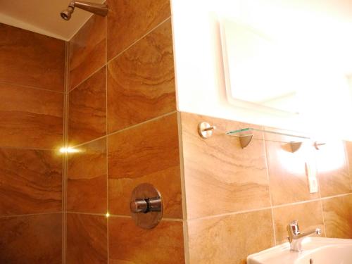 赖因斯贝格Villa Sperlingslust的带淋浴、水槽和镜子的浴室