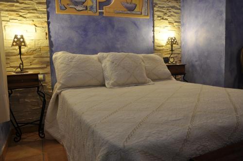 莱图尔Casa Rural El Pajar del Portalico的一间卧室配有白色床和2个床头柜