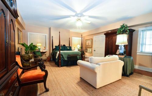 纳奇兹Choctaw Hall Bed & Breakfast的客厅配有床和白色椅子
