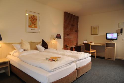 杜塞尔多夫空中瓦尔特堡酒店的酒店客房设有一张大床和一张书桌。