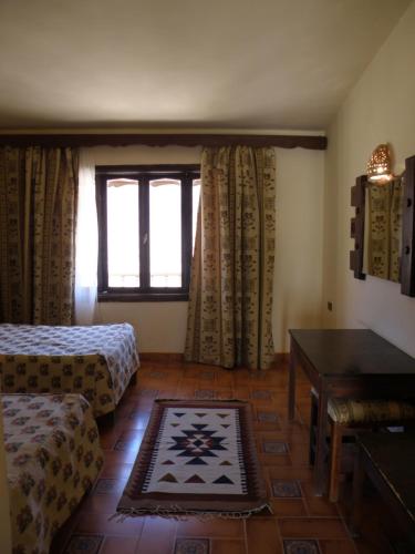 圣凯瑟琳圣凯瑟琳丹妮拉村庄酒店的客房设有床、桌子和窗户。