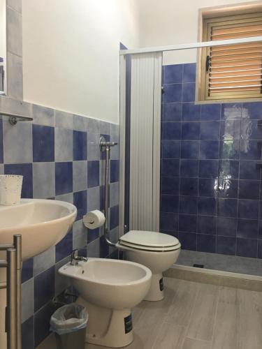 马尔扎梅米弗特村酒店的蓝色瓷砖浴室设有卫生间和水槽