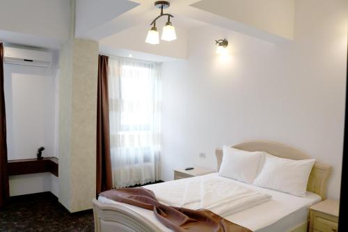 锡吉什瓦拉Hotel Restaurant Imperial的卧室配有白色的床和窗户。