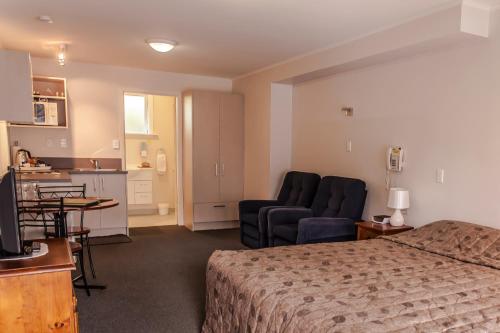 基督城艾舍乐格苑汽车旅馆的酒店客房设有床、沙发和厨房。