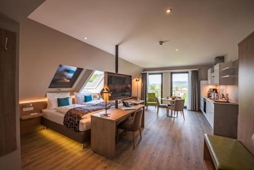 戈斯拉尔AKZENT Hotel Villa Saxer的一间带一张床和一张书桌的卧室和一间厨房