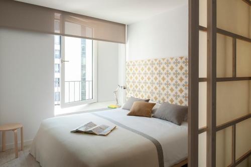汉堡埃里克沃克尔精品公寓 - 汉堡套房的卧室设有一张白色大床和一扇窗户。