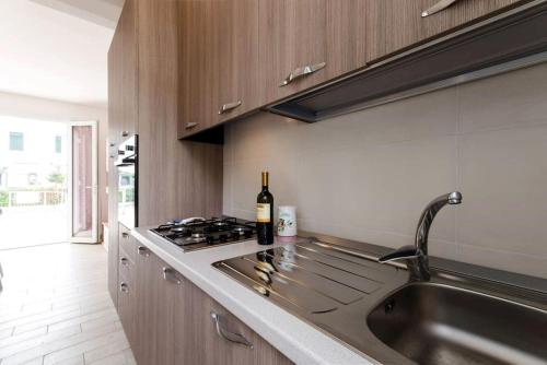 利多波波萨Villa Demì的厨房配有水槽和一瓶葡萄酒