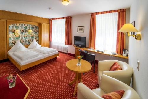 希尔塔赫苏姆维森罗斯勒酒店的酒店客房带一张床、一张桌子和椅子