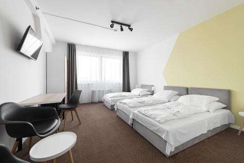 布达佩斯切斯康酒店的酒店客房带两张床和一张桌子以及椅子。